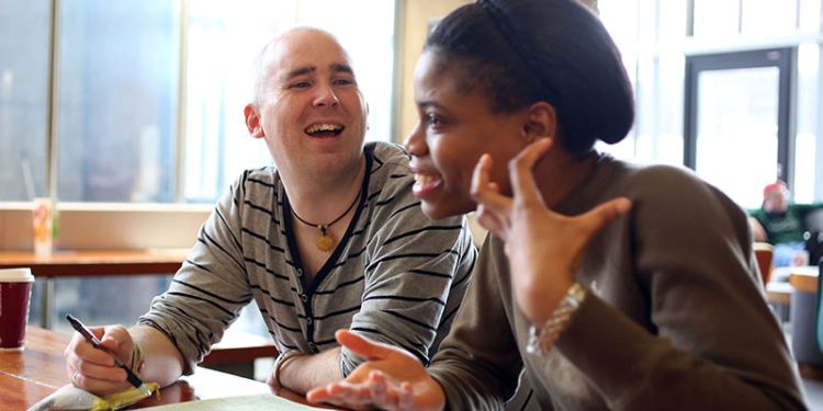 Two University of Leeds students sat on campus talking about fees and studentships