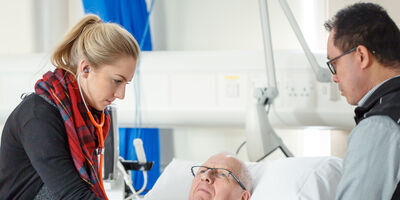 Doctor using a stethoscope to listen to a male patients heart and lungs