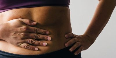 Someone holding their stomach in pain.
