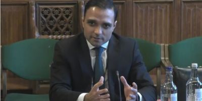 Dr Stuart Flint sitting at a desk, speaking during the Health and Social Care Committee meeting inquiry