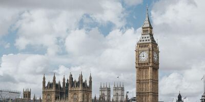 The houses of parliament with Big Ben on the right and the London Bridge in front.