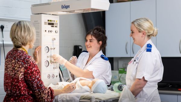 Two midwifery students work with a tutor in the Clinical Skills suite