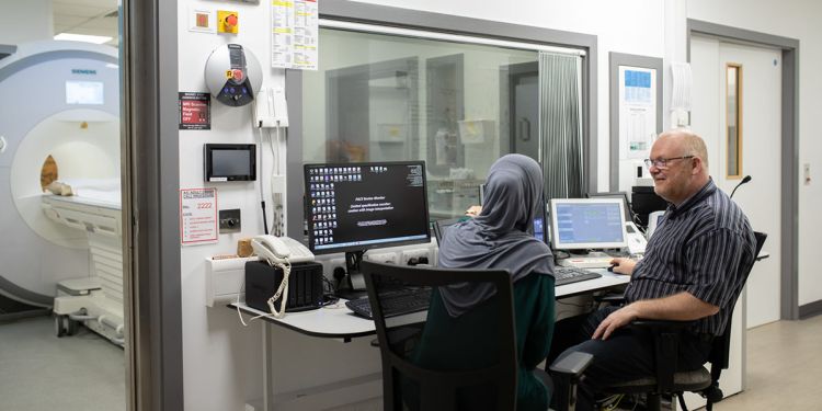 Phd imaging student and staff looking at images