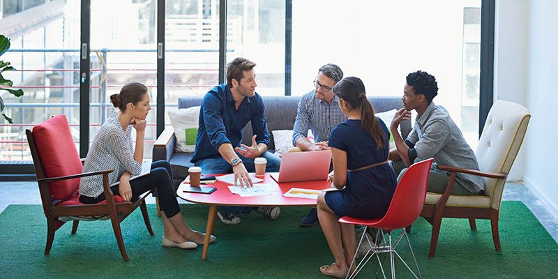 Group of students sat around a table working together