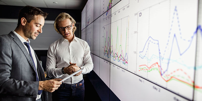 Academics looking at research and innovation data on a screen representing research at the School of Psychology at the University of Leeds